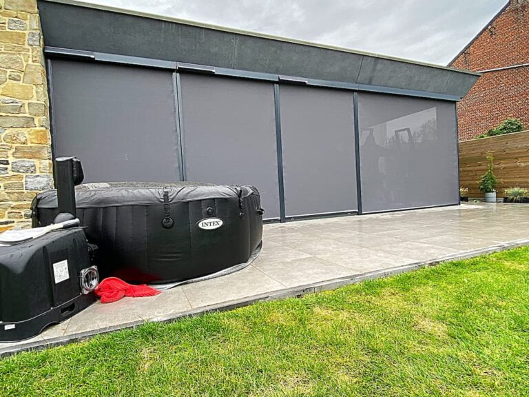 Screen solaire gris sur terasse en carrelage gris clair, un jacuzzi noir sur la terasse